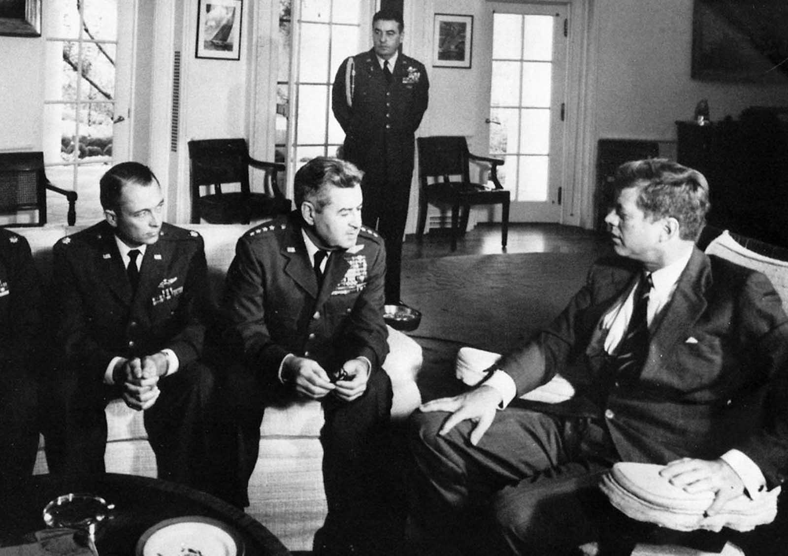 President John F. Kennedy meets with Air Force Maj. Richard Heyser, left, and Air Force Chief of Staff, Gen. Curtis LeMay, center, at the White House in Washington to discuss U-2 spy plane flights over Cuba.