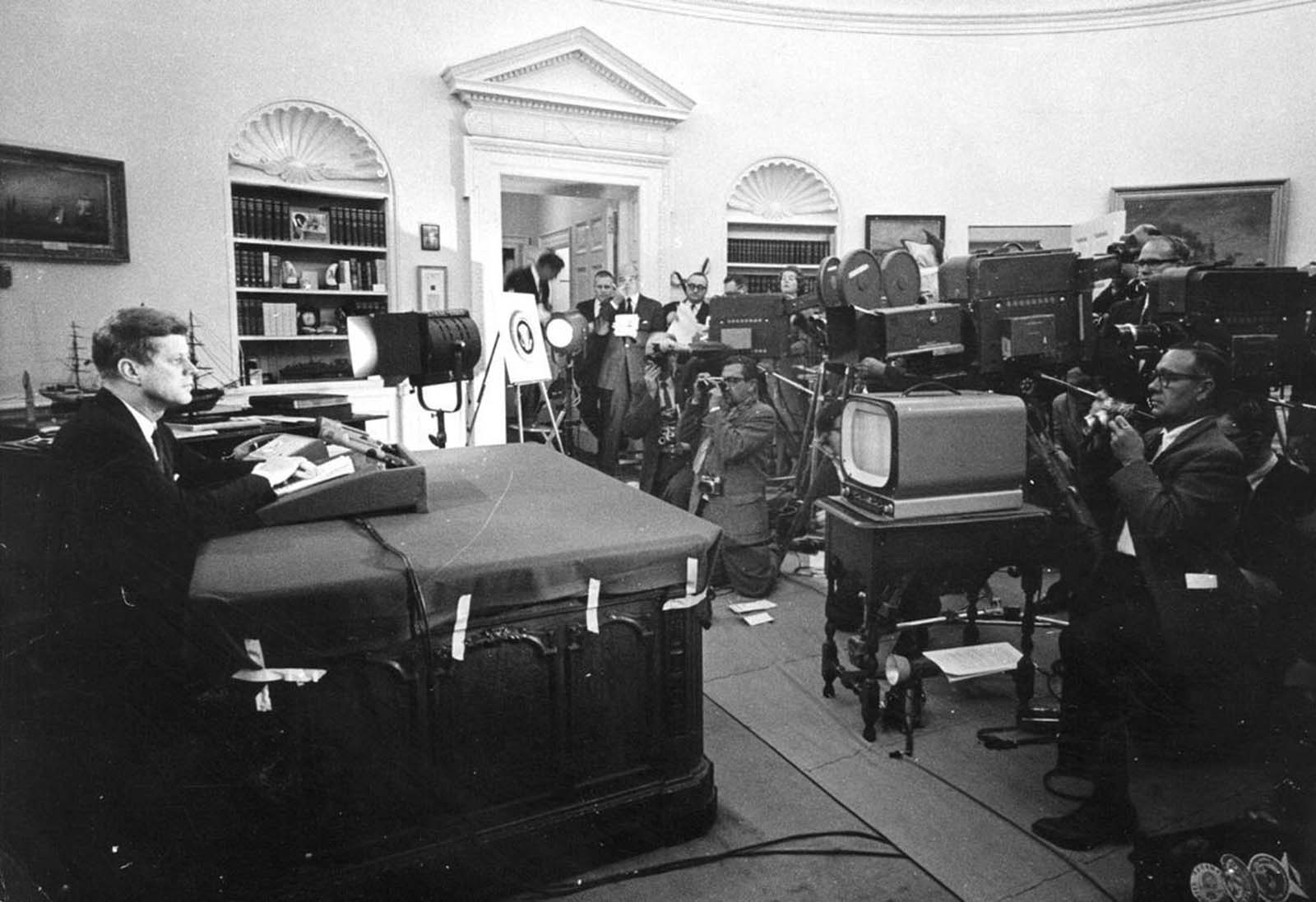 U.S. President John F. Kennedy speaks before reporters during a televised speech to the nation about the strategic blockade of Cuba, and his warning to the Soviet Union about missile sanctions, during the Cuban missile crisis, on October 24, 1962 in Washington, DC.