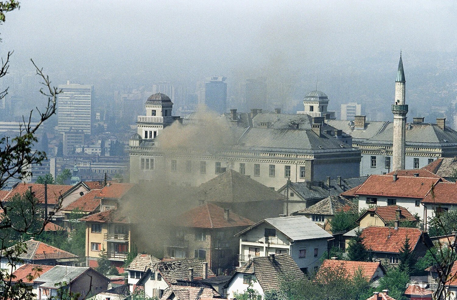 Smoke rises from the Jajce barracks Tuesday after it was hit by artillery fired by the Yugoslav Army from the hills surrounding Sarajevo, the Bosnian capital. Army artillery pounded Sarajevo on Tuesday, May 5, 1992 leaving the city cloaked in flames…